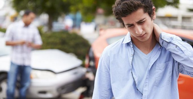 a young man touching his neck from auto accident injury in Grand Rapids, MI