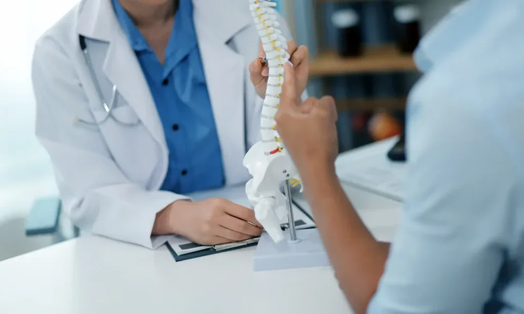 A doctor is shown consulting with a patient about their spine health in a modern medical office. This image depicts a professional consultation in Grand Rapids, MI.