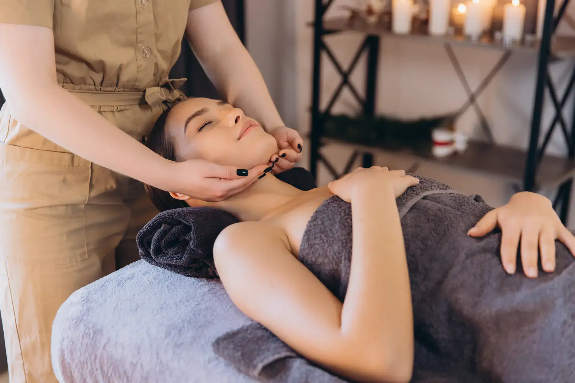 A client is receiving a gentle facial massage from a professional therapist in a calm spa setting. This relaxing scene is typical of wellness and beauty services offered in Grand Rapids, MI.