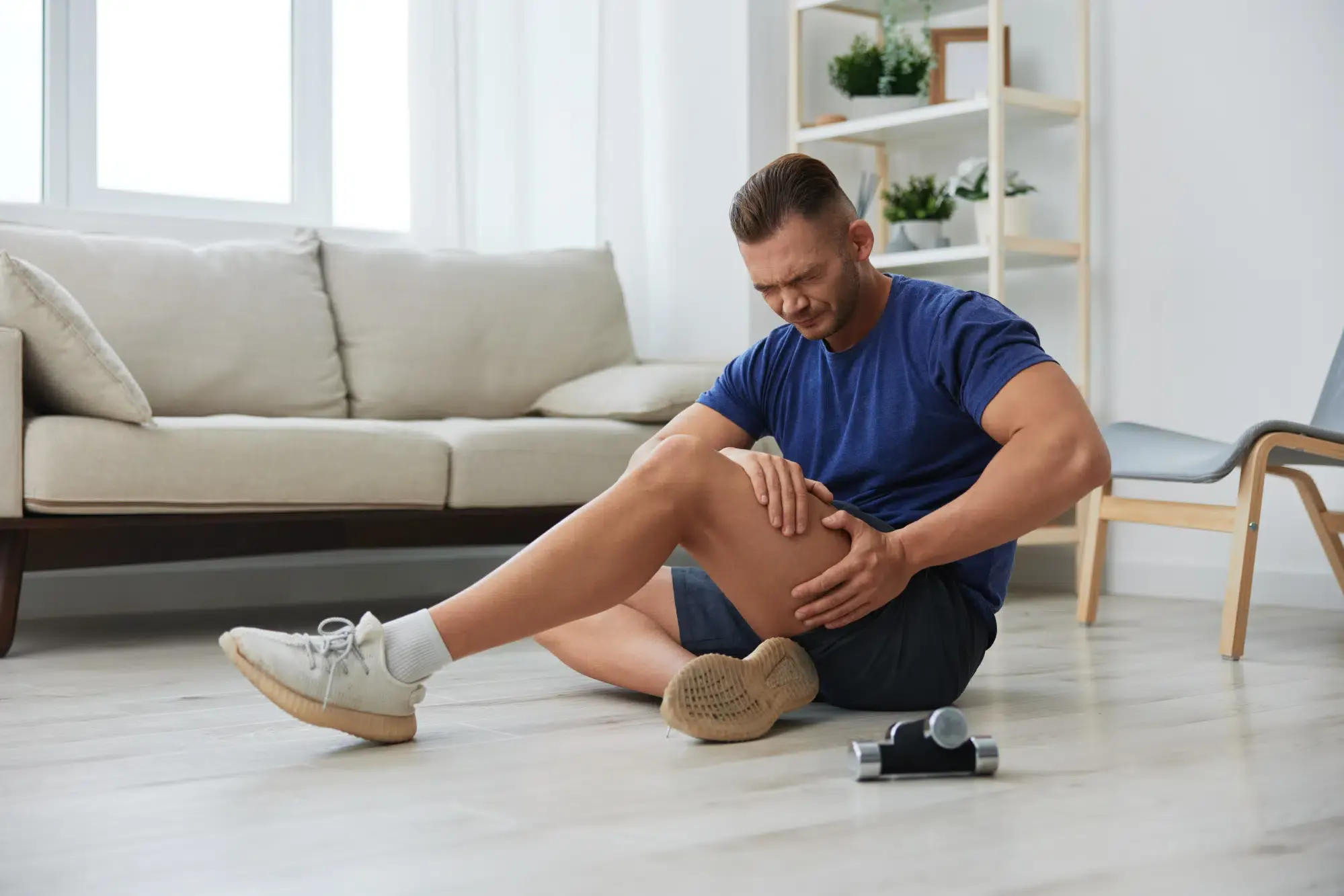 A casual portrait of a man sitting on the ground with a relaxed posture, holding his leg. This image depicts a serene moment in Grand Rapids, MI.